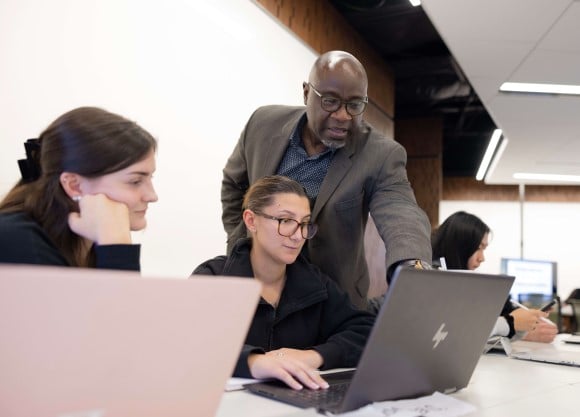 Learners sitting at a computer in the School of Business