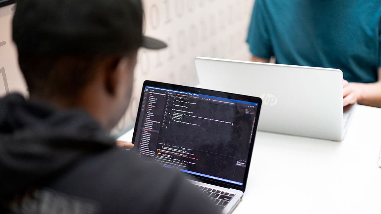 Student facing a laptop during the hack-a-thon