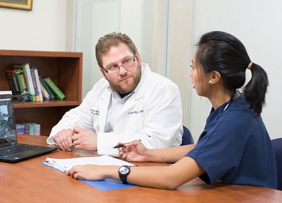 nurse talking with a doctor at a desk