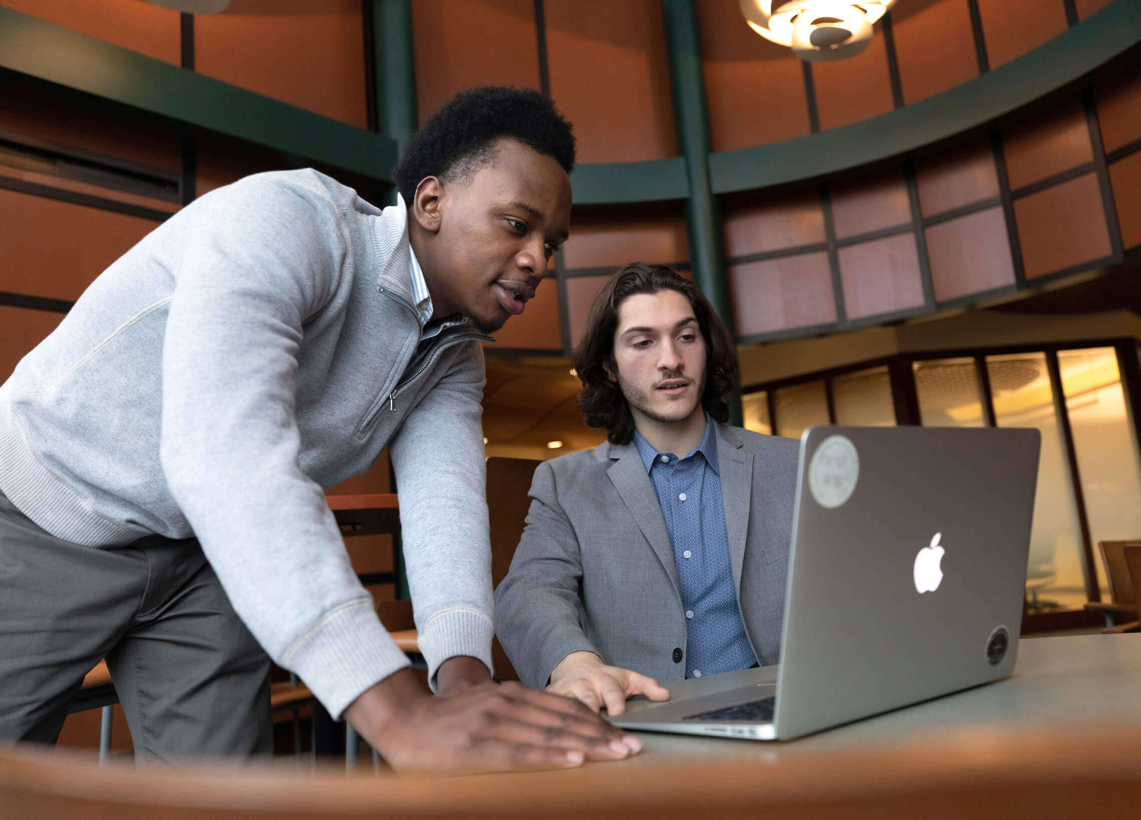 Two students  work collaboratively on a laptop computer